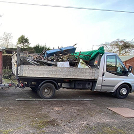 White commercial dump truck loaded with scrap metal and recycled materials